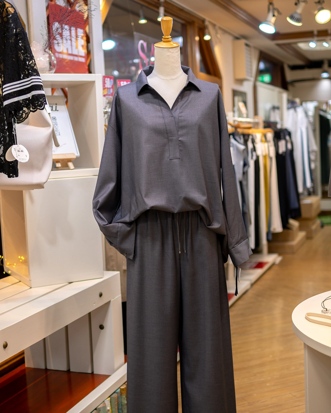 グレーのスキッパー襟長袖プルオーバーとワイドパンツのイージーセットアップ